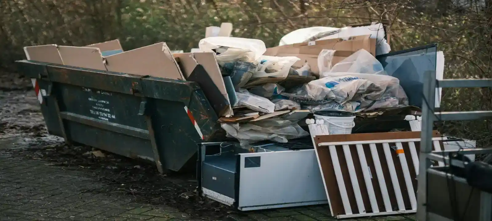 Large amount of cardboard waste placed around and on a skip bin, showing the need for skip bins townsville qld waste management service