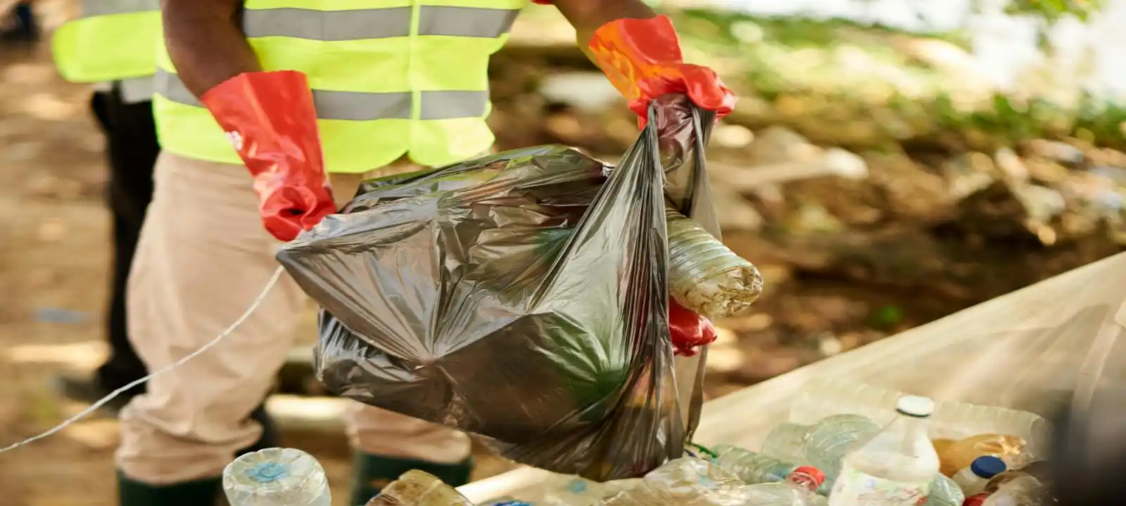 Staff placing rubbish into black bags as part of affordable rubbish removal townsville service