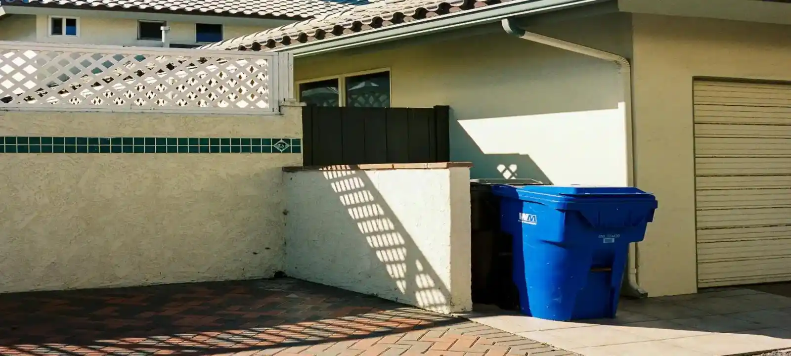 Medium blue skip bin placed beside a residential property for skip bin hire townsville prices service for easy household waste disposal